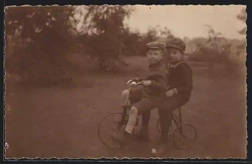 Foto-AK Zwei freche Buben auf einem Dreirad sitzend