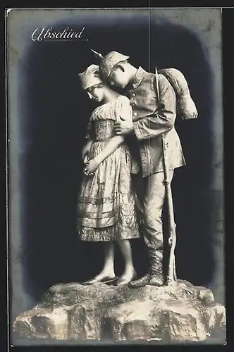 Foto-AK vermenschlichte Statue: Soldat in Uniform mit Pickelhaube u. Gewehr nimmt Abschied von seiner Liebsten