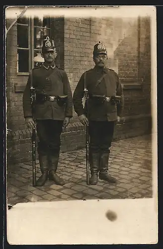 Foto-AK Landsturm Soldat und Uffz. in Uniform mit Taschako und Gewehr bei Fuss