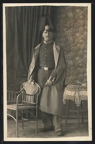 Foto-AK Gardesoldat in Uniform mit Pickelhaube Rosshaarbusch und Uniformmantel
