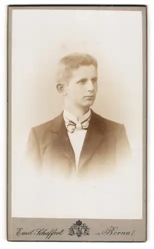 Fotografie Emil Schuffert, Borna i. S., Am Bahnhof, Gutaussehender junger Mann mit Bürstenschnitt und Fliege