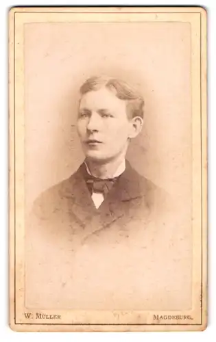 Fotografie W. Müller, Magdeburg, Berlinerstr. 9, Junger blonder Mann mit hohen Wangenknochen und Fliege