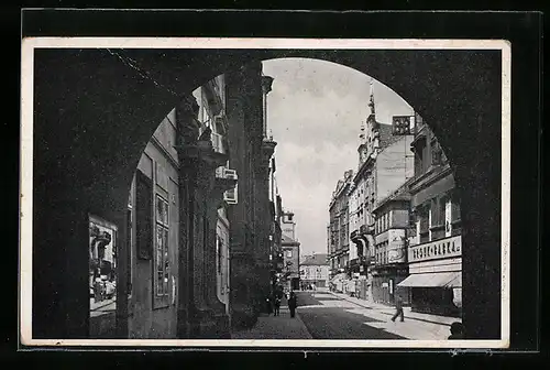 AK Pilsen, Strassenpartie mit Geschäften durch ein Tor