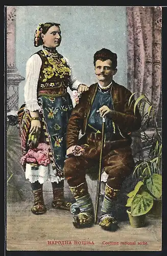 AK Paar in serbischen Trachten mit Gehstock und Pflanzen