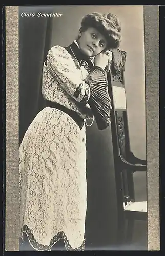 AK Opernsängerin Clara Schneider lehnt an einem Stuhl