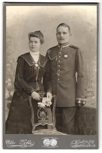 Fotografie Otto Witte, Berlin, Uffz. in Garde Uniform mit Orden und Schützenschnur, nebst seiner Frau