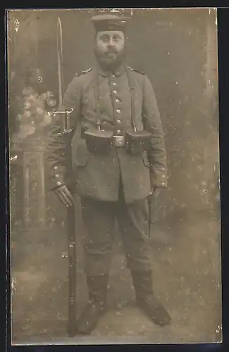 Foto-AK Soldat in Feldgrau Uniform mit Bajonett auf Gewehrt, Munitionstaschen