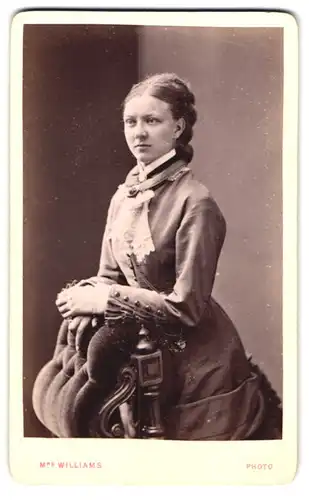 Fotografie Mrs. Williams, Wolverhampton, junge Engländerin im Kleid am Gründerzeitstuhl
