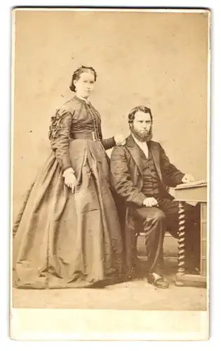 Fotografie National Photographic Institution, Belfast, nordirisches Paar im Kleid und Anzug am Sekretär sitzend