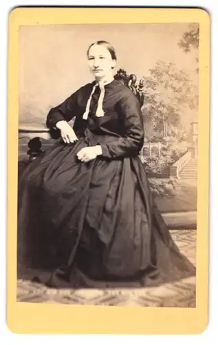 Fotografie Rob. Reichenbach, Bischofswerda, junge Frau im dunklen Kleid vor einer Studiokulisse