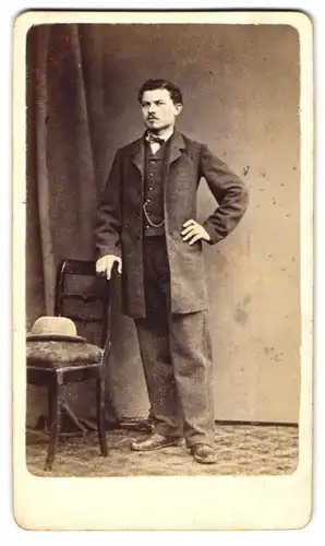 Fotografie A. Gasser, Hall, Portrait Herr Herlinger im Anzug mit Hut auf dem Stuhl, 1870