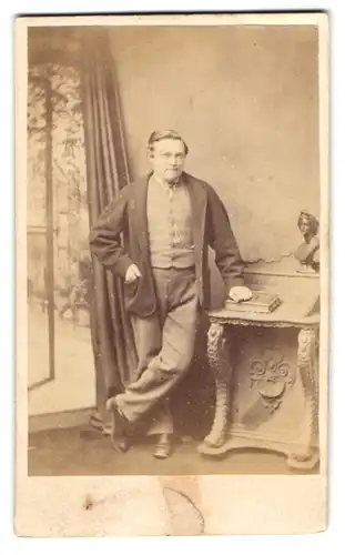 Fotografie Jones, Marlborough, englischer Herr im Anzug lehnt am Sekretär