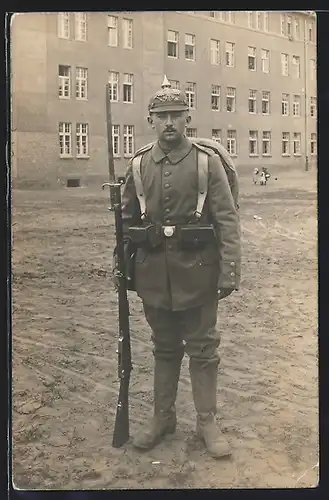 Foto-AK Soldat in Feldgrau Uniform Rgt. 46 mit Ersatz Pickelhaube, Ausmarschgepäck, Bajonett auf Gewehr, Kriegsausmarsch