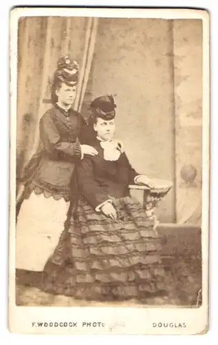 Fotografie F. Woodcock, Douglas, zwei englische Damen in Biedermeierkleidern mit Hut