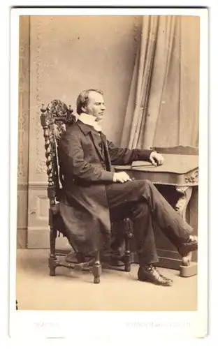 Fotografie Sawyer, Norwich, englischer Herr im Anzug mit hohen Kragen sitzt im Korkenzieher Stuhl