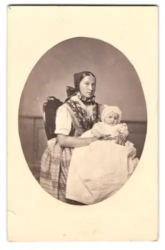 Fotografie unbekannter Fotograf und Ort, Mutter im Trachtenkleid mit Kind auf dem Schoss