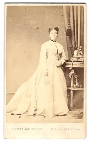 Fotografie G. J. Tear, London, Dame im weissen Kleid mit Brosche und Ohrringen