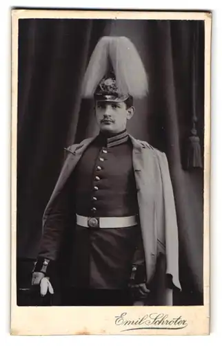 Fotografie Emil Schröter, Jüterbog, Soldat in Gardeuniform mit Pickelhaube Preussen Rosshaarbusch und Mantel