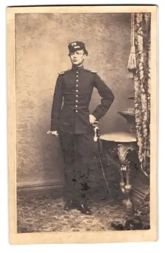 Fotografie unbekannter Fotograf und Ort, junger Soldat in Uniform mit Epauletten und Säbel