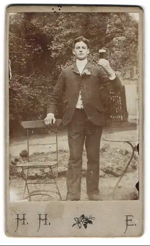 Fotografie unbekannter Fotograf und Ort, junger Mann im Biergarten mit Schwarzbier Glas prost der Kamera zu