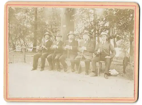 Fotografie unbekannter Fotograf und Ort, fünf Herren rasten auf einer Parkbank mit Stock und Hut