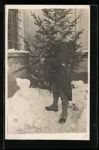 AK Österreichischer Soldat in Uniform vor Tannenbaum