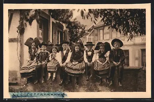 AK Kinder auf einer Mauer sitzend tragen die elsass-lothringische Tracht