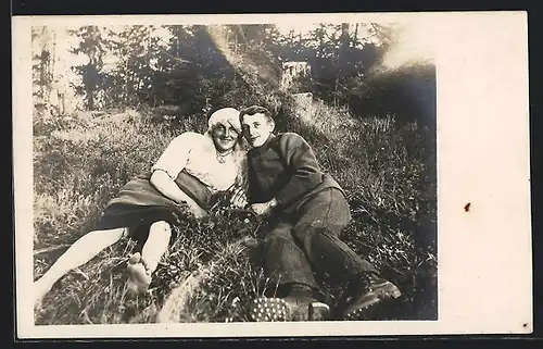 Foto-AK Junges Paar auf einer Wiese, Mann als Frau gekleidet, Travestie
