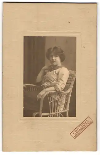 Fotografie C. Drühmel, Geesthacht, Bergedorferstr. 41, Junge hübsche brünette Frau lässig auf einem Stuhl sitzend
