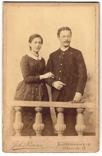 Fotografie Joh. Beine, Lüdenscheid, Altenaerstr. 12, Junges gutaussehendes Paar mit Brille, Schnauzer und Kette