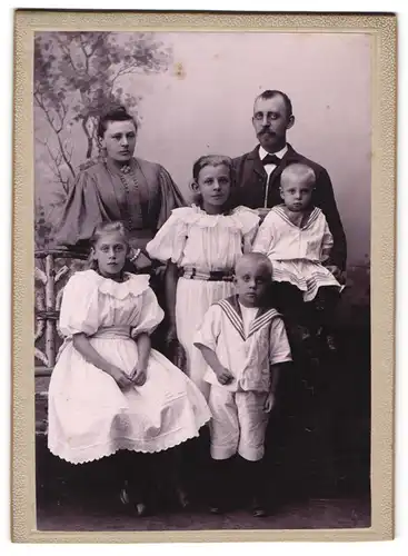 Fotografie unbekannter Fotograf und Ort, Bürgerliche Familie in zeitgenössischer Kleidung