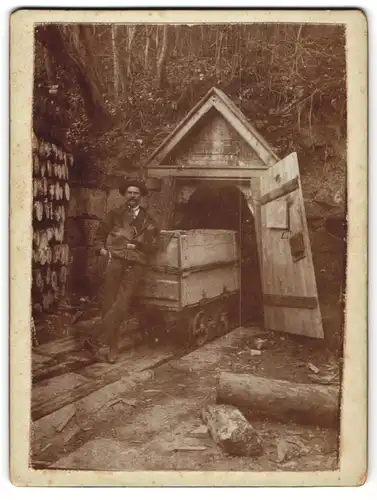 Fotografie unbekannter Fotograf, Ansicht Georgenberg, Bergmann mit Lore am Schachteingang Schild Aufschrift Georgenberg