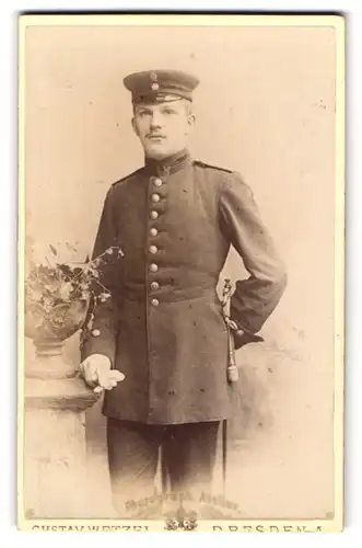 Fotografie Gustav Wetzel, Dresden, Beamter / Briefträger in Uniform mit Säbel an der Seite