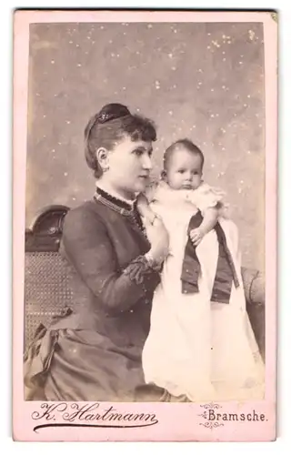 Fotografie K. Hartmann, Bramsche, junge Mutter im dunklen Kleid mit ihrem Kind im Arm, Mutterglück