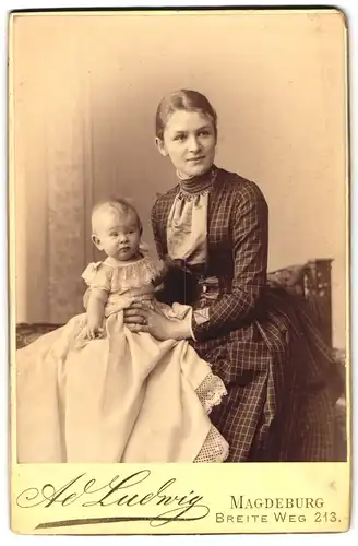 Fotografie Ad. Ludwig, Magdeburg, junge Mutter im karierten Kleid mit ihrem Kind auf dem Schoss