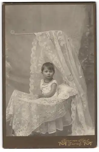 Fotografie Meier von Tobel, Zürich, niedliches kleines Mädchen sitzt im Kinderbett und Betet