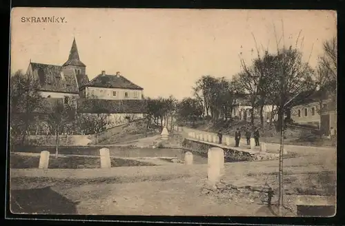 AK Skramniky, Strassenpartie am Wasser mit Blick zur Kirche