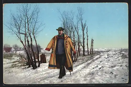 AK Ungar im traditionellen Mantel spaziert auf einem verschneiten Feldweg
