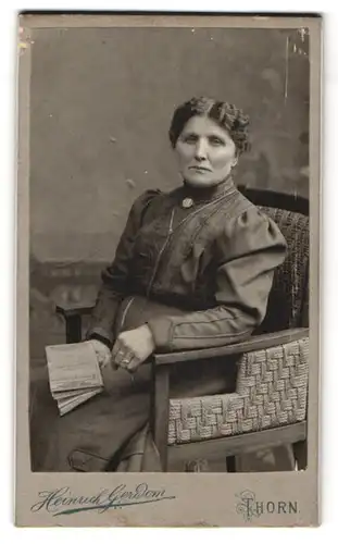 Fotografie Heinrich Gerdom, Thorn, Bürgerliche Dame im schwarzen Kleid mit Brosche und Buch