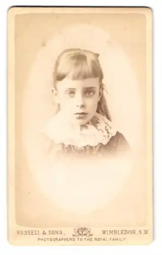 Fotografie Russell & Sons, Wimbledon, Junges Mädchen im hellen Kleid schaut gelangweilt in die Kamera
