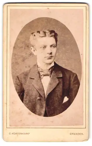 Fotografie C. Kortenkamp, Dresden, Annenstr. 35, Junger Bursche im Anzug mit grosser Fliege und Mittelscheitel
