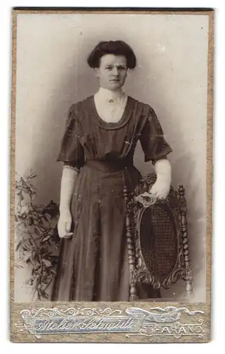 Fotografie A. Schmidt, Tharand, Junge Dame im schwarzen Kleid mit weissen Handschuhen und Brosche