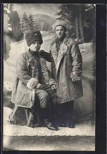 Foto-AK Zwei Männer mit Fellmützen und -mänteln vor Fotokulisse