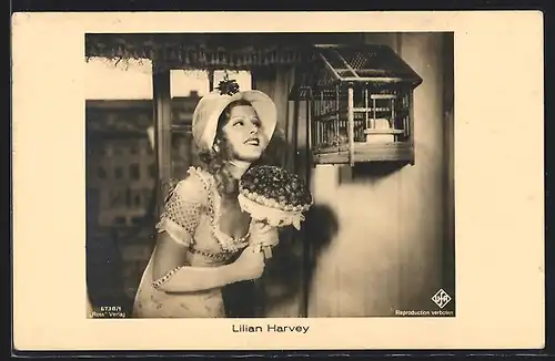 AK Schauspielerin Lilian Harvey mit Blumen vor einem Vogelkäfig stehend
