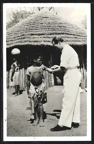 AK Arzt untersucht in einem afrikanischen Dorf einen kleinen Jungen, afrikanische Volkstypen