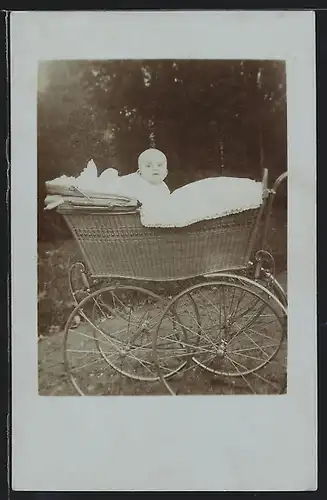 Foto-AK Süsses Baby schaut neugieríg aus dem Kinderwagen