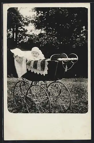 Foto-AK Niedliches Baby schaut neugierig aus dem Kinderwagen