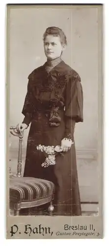 Fotografie P. Hahn, Breslau, Gustav Freytagstr. 3, Attraktive junge Frau mit konzentrierter Miene und Blütenzweig