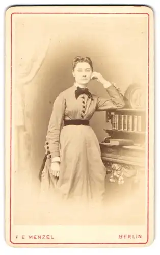 Fotografie F. E. Menzel, Berlin, Portrait junge Dame im hellen Kleid posiert am Sekretär