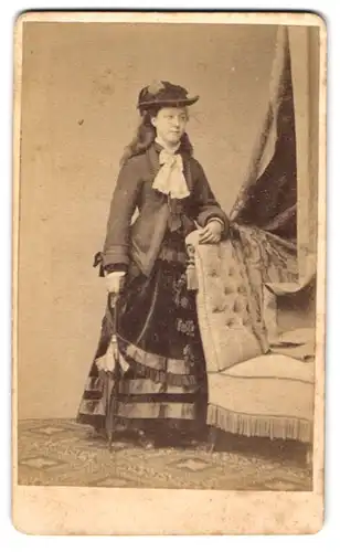 Fotografie Fr. Kahlmeyer, Osnabrück, hübsche junge Frau im dunklen Kleid mit Jacke und Hut, Sonnenschirm
